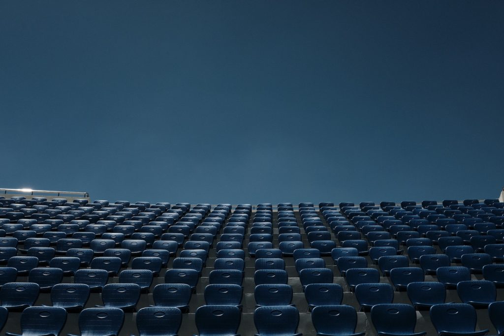 a stadium filled with blue seats under a blue sky