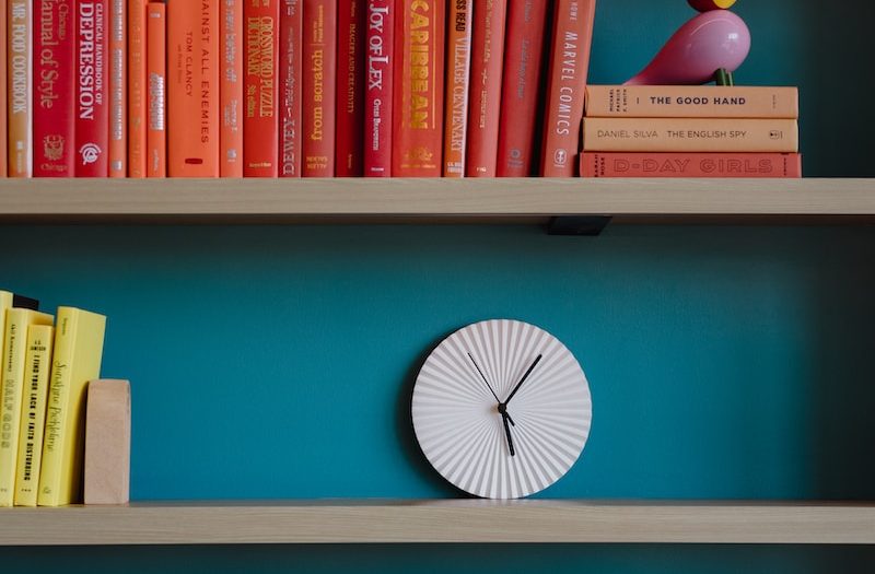 a bookshelf filled with books and a clock