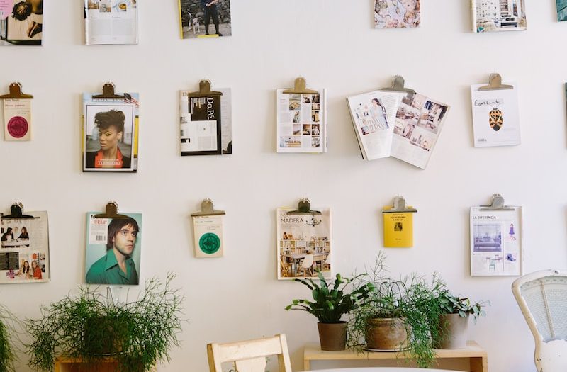 magazines hanged on wall near round beige wooden table