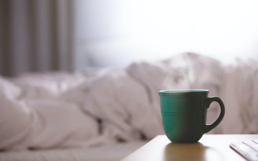 green ceramic mug on wooden desk