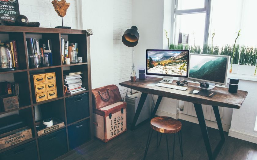 two flat screen monitor turned on near organizer rack inside the room