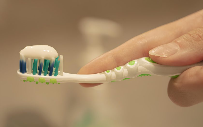 a person is holding a toothbrush with toothpaste on it