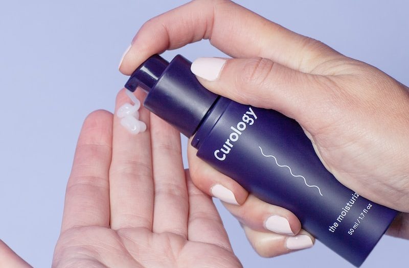 person holding Curology spray bottle