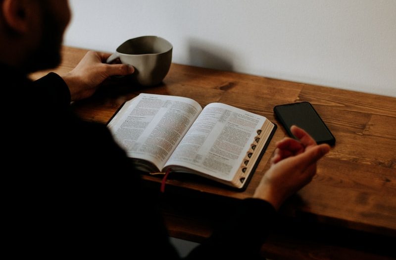 man in black shirt reading book