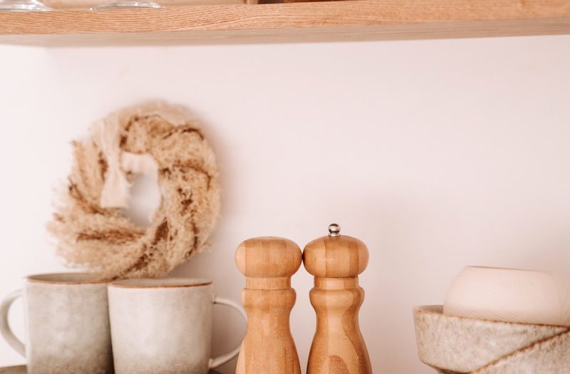 a shelf filled with dishes and cups on top of a wooden shelf