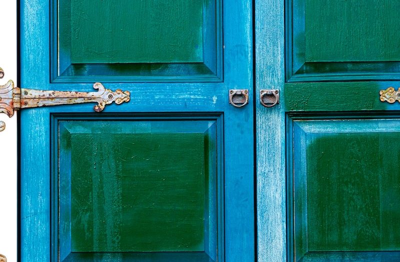 a close up of a blue door with a clock on it